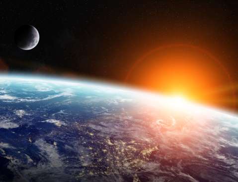 A space of Earth's atmosphere and space with the sun peaking out.