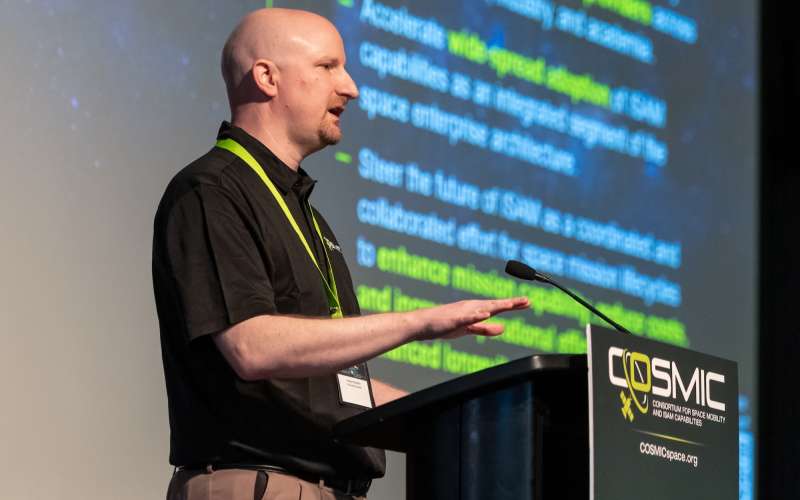 COSMIC executive director Greg Richardson at a podium.