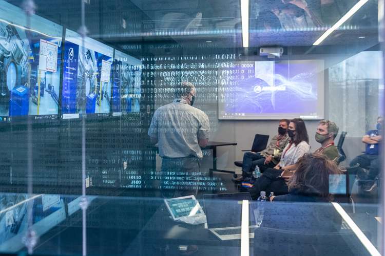 Picture of people in a board room looking at a TV screen