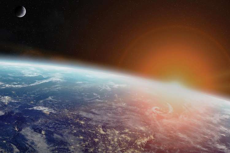 View of Earth from orbit with Sun in the background.