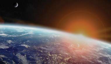 View of Earth from orbit with Sun in the background.