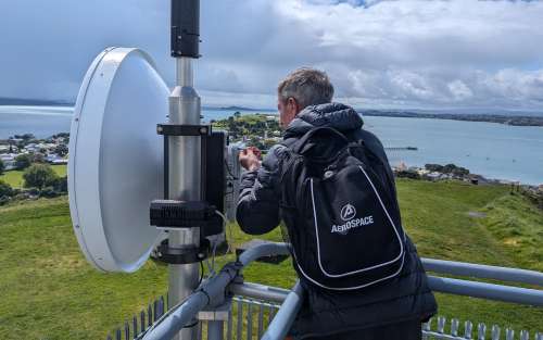 Aerospace project leader Andrew Moulthrop adjusts the transmitting antenna at the V-/W-band experiment’s transmitter site at Mt. Victoria.